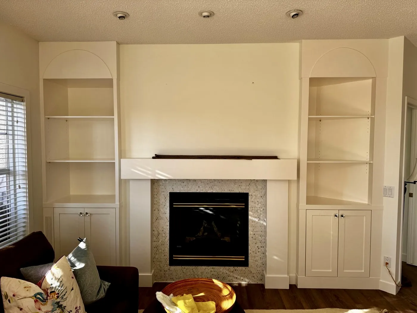 Fireplace with freshly painted white built-in shelves in Calgary