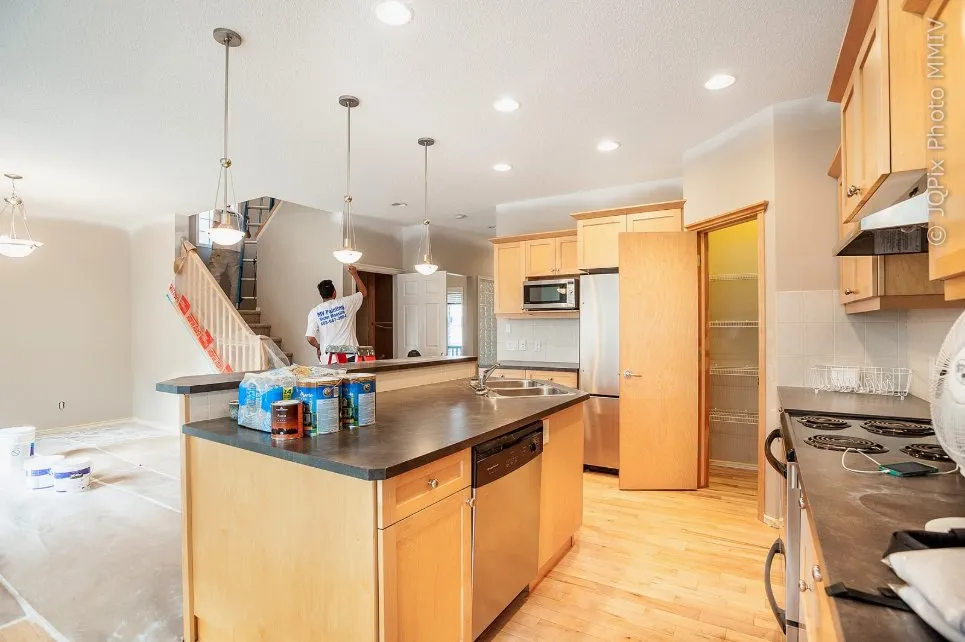MV Painting Inc. painter refinishing kitchen cabinets on site, Calgary