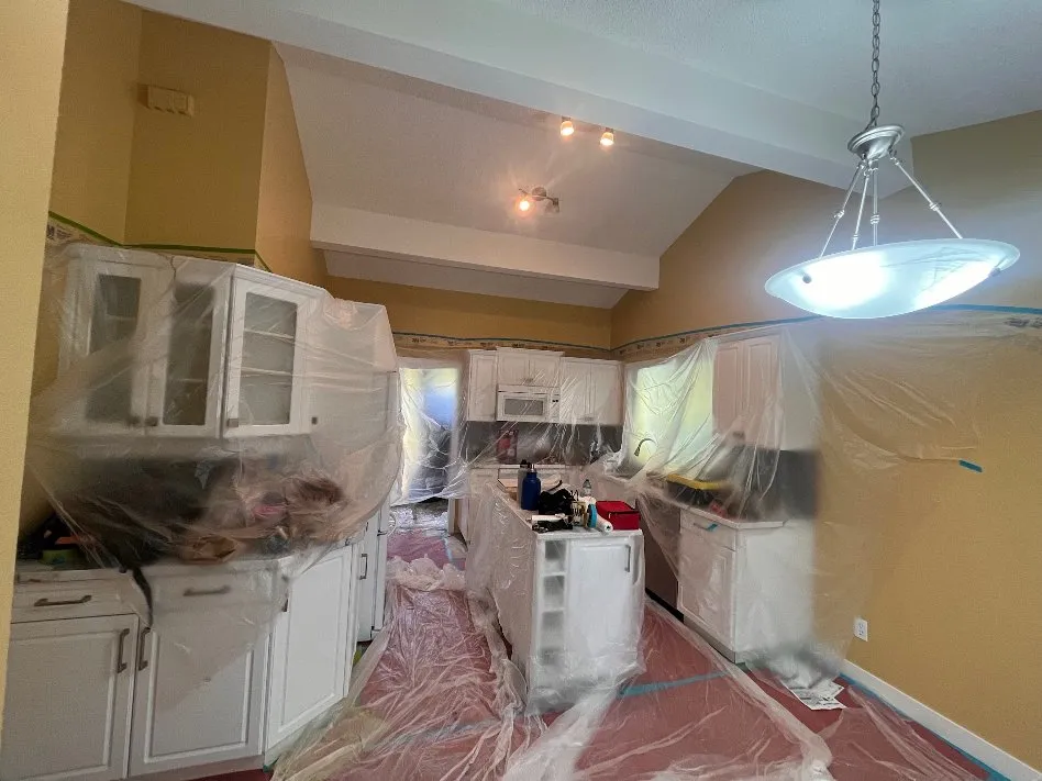 Kitchen masked and protected for cabinet spraying in progress, Calgary