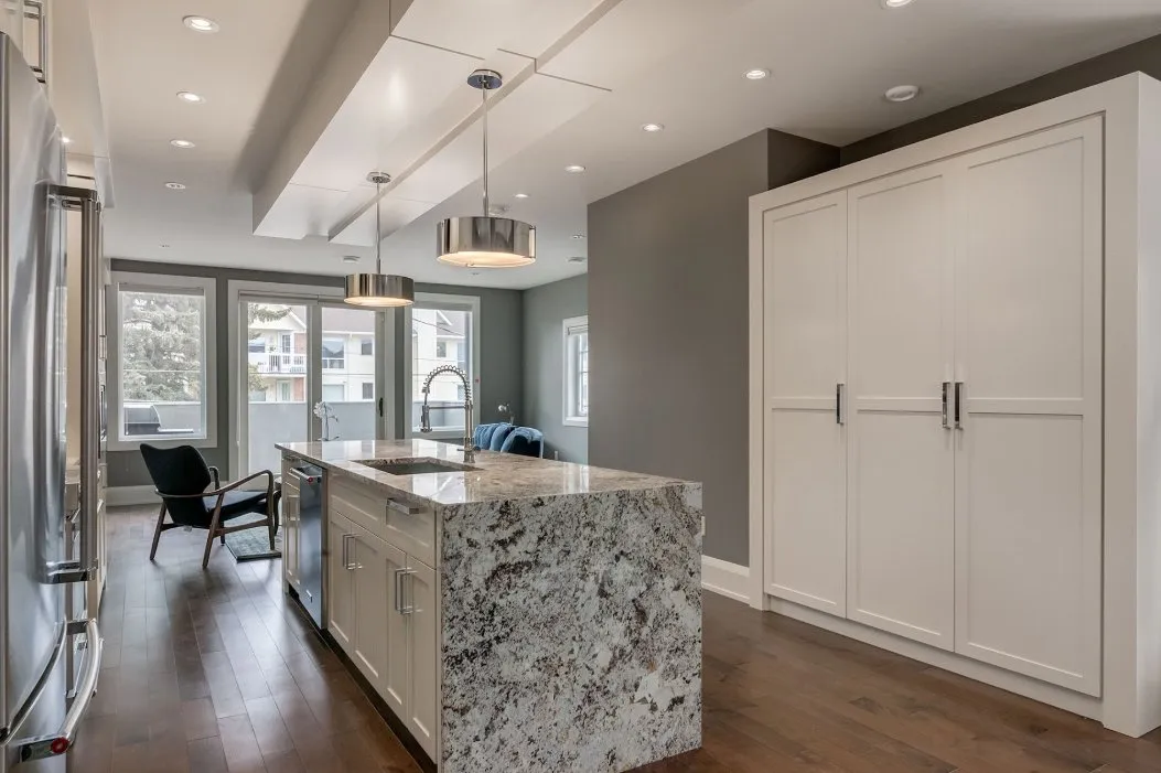 Kitchen island with pendant lighting and freshly painted walls in Calgary