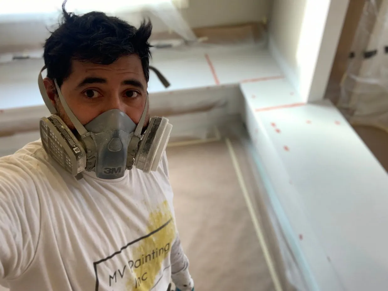 MV Painting Inc. painter wearing respirator protection on a spray job in Calgary
