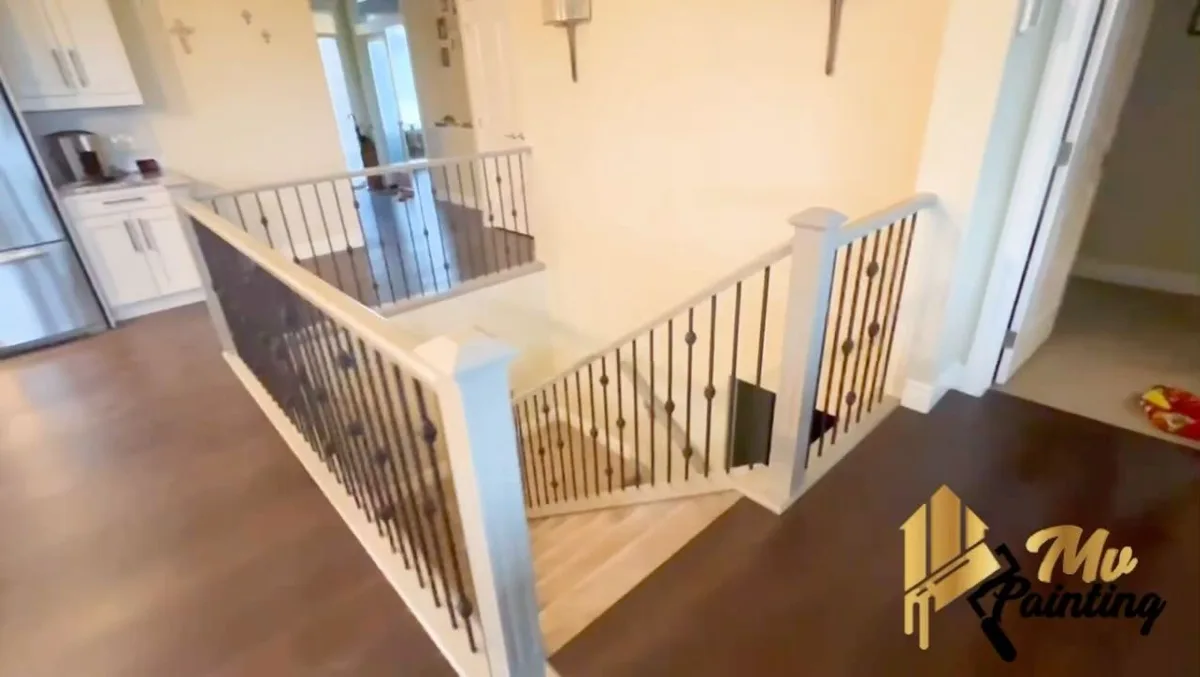 Finished staircase railing with white posts and dark metal spindles, Calgary