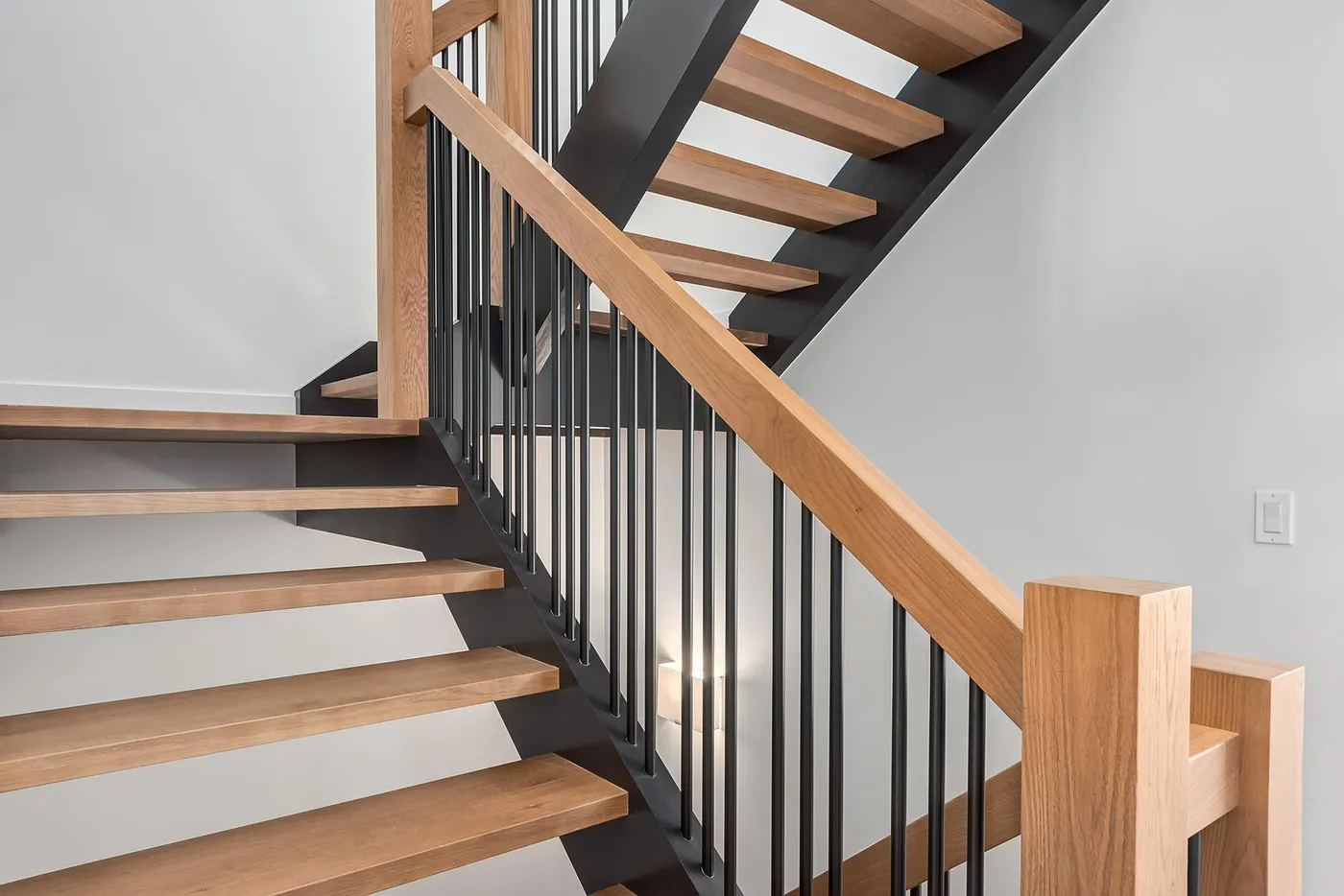 Staircase with painted walls, wood steps and black railing in Calgary