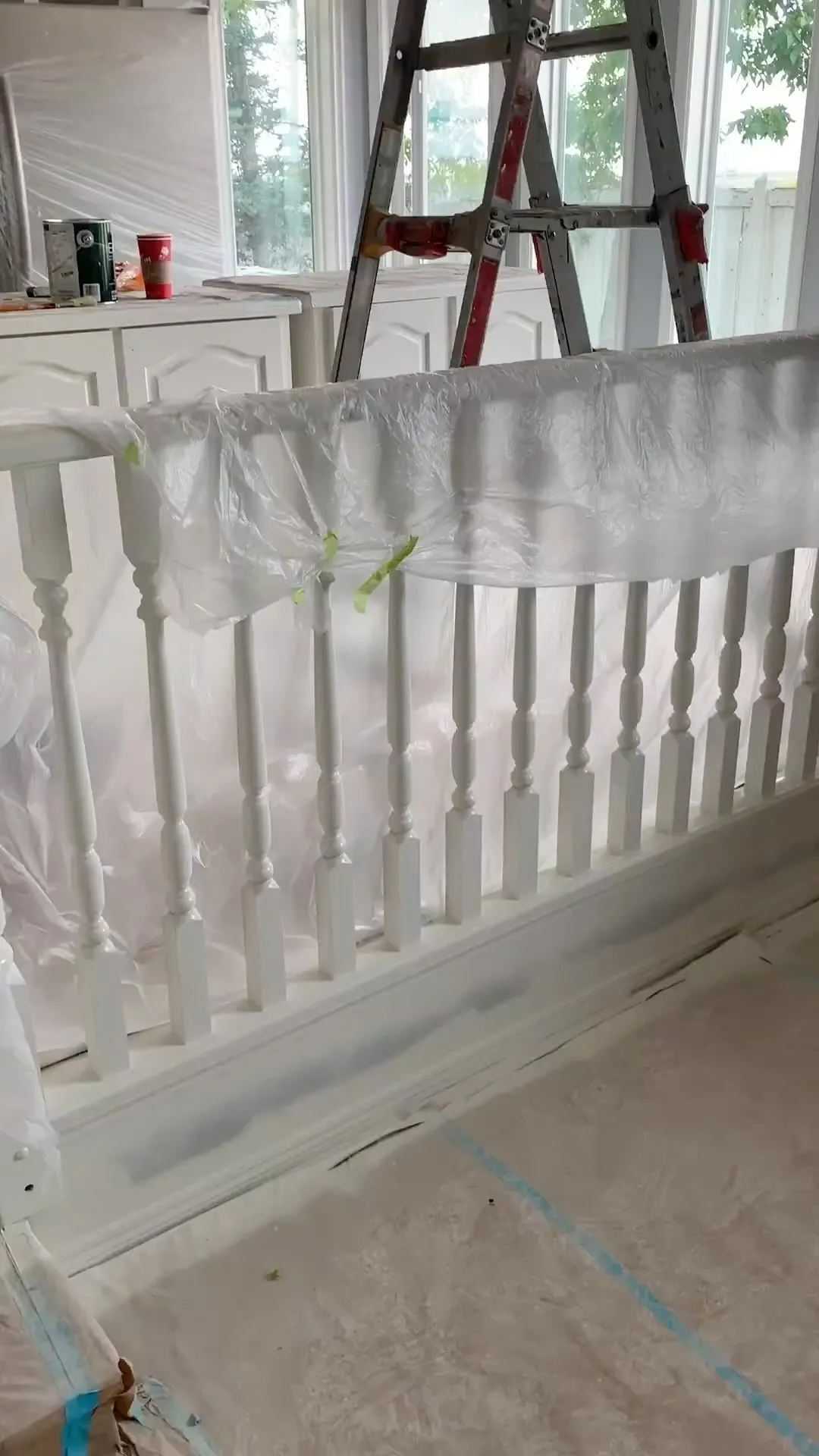 Staircase spindles masked and sprayed during refinishing in Calgary