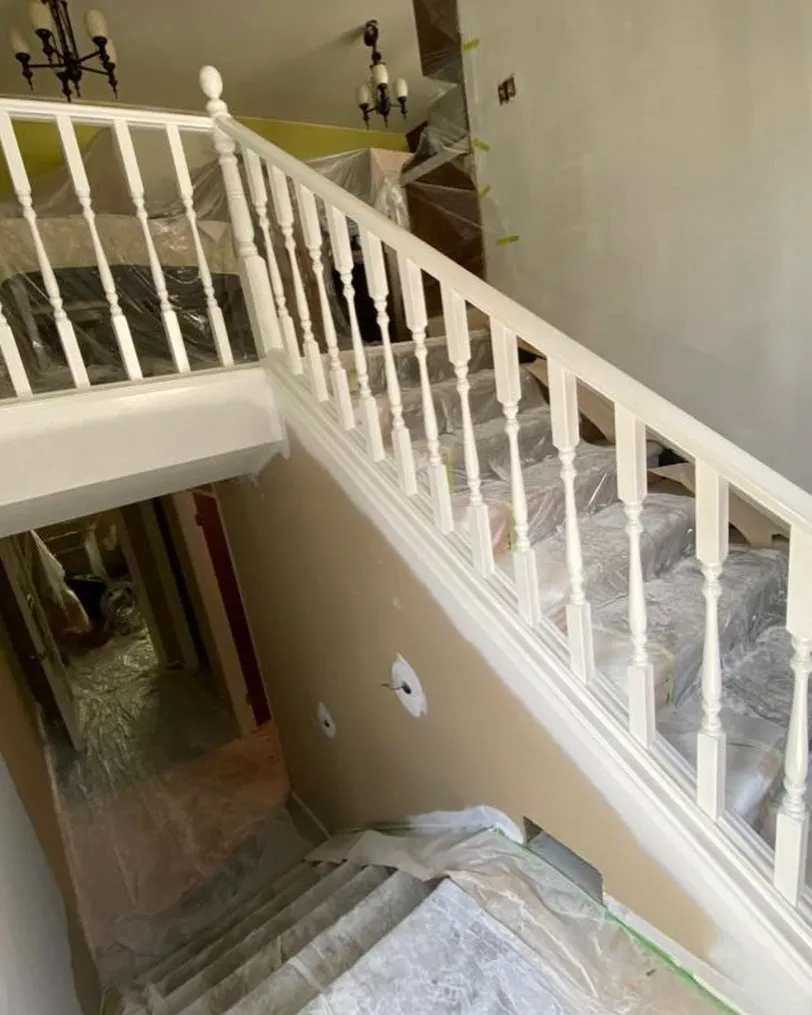 White staircase spindles being sprayed on site in Calgary