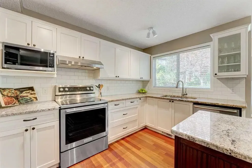 White kitchen with freshly painted cabinets and subway tile backsplash in Calgary