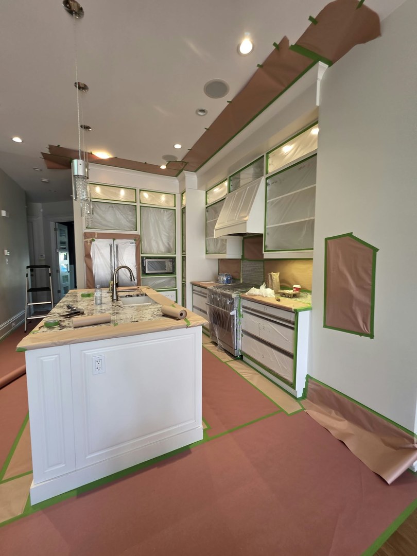 Kitchen cabinet refinishing in Altadore, Calgary: full masking and protection, then a sprayed factory-style finish on cabinets, island and panels, with a video walkthrough of the finished kitchen.