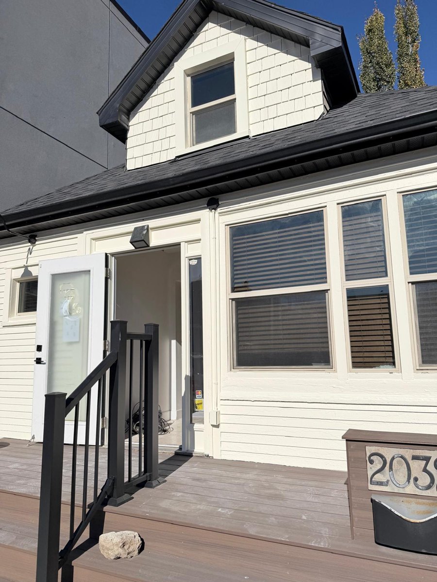 Storefront repainted in warm cream with a deep green entry door in Calgary