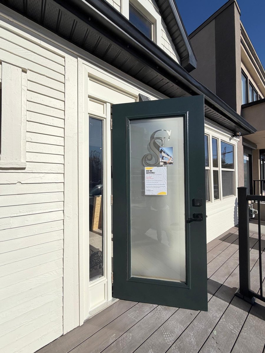 Entry door repainted in deep green with warm cream siding in Calgary