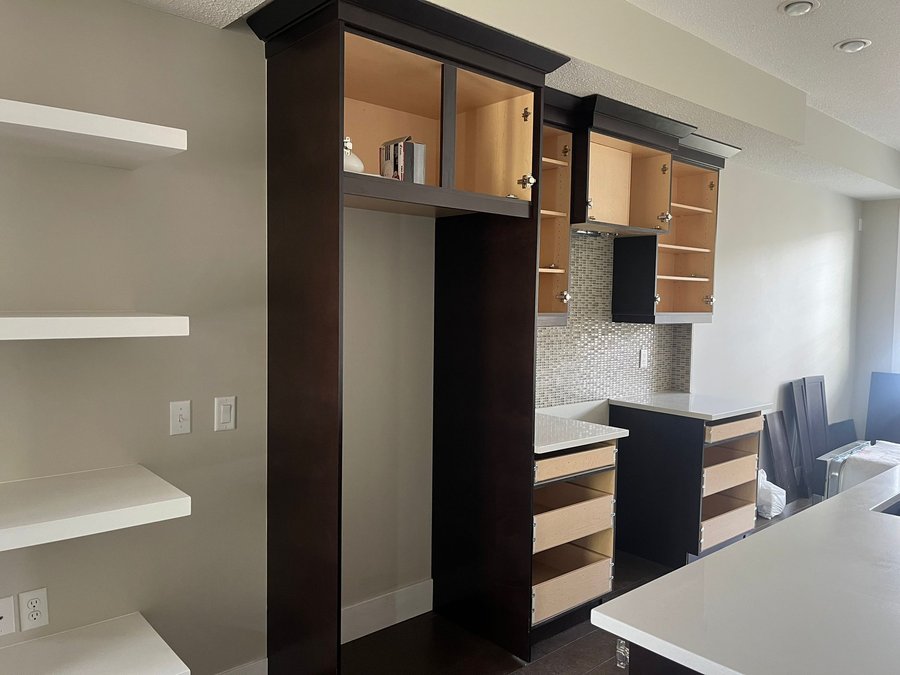 Kitchen cabinets with doors and drawers removed for refinishing in Quarry Park, Calgary