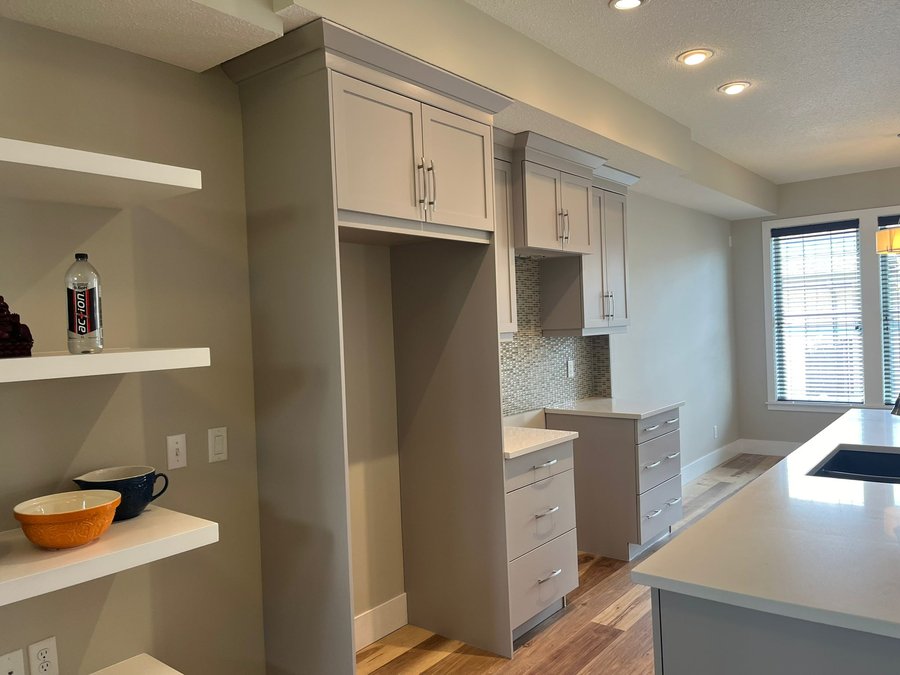 Refinished kitchen cabinets in a warm off-white, wide view