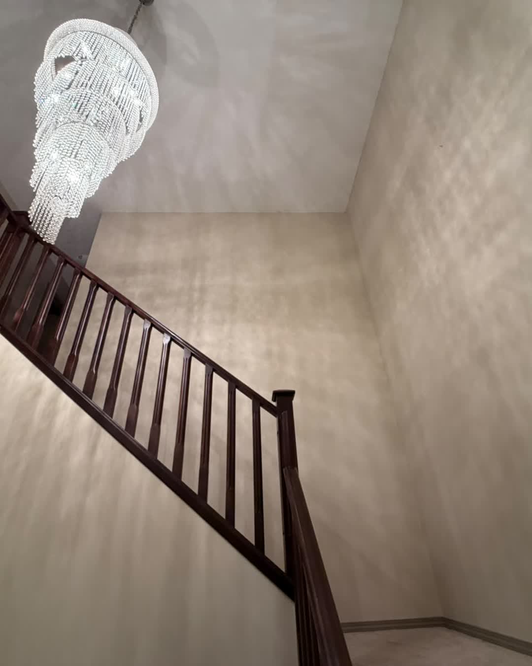 Freshly painted staircase with chandelier after a full interior repaint in Cranston, Calgary by MV Painting Inc.