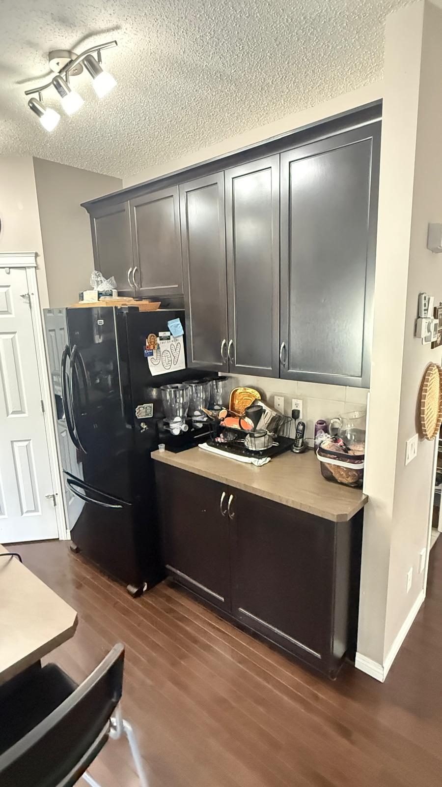 Dark espresso shaker kitchen cabinets before refinishing in Kincora, Calgary