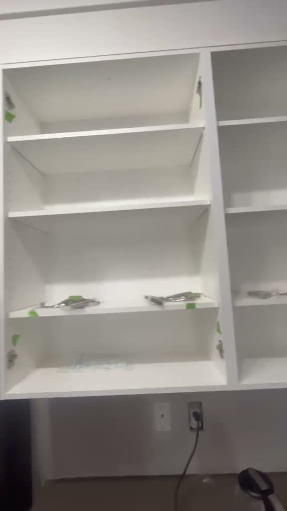 Cabinet frames sprayed white with the doors removed during refinishing in Kincora, Calgary