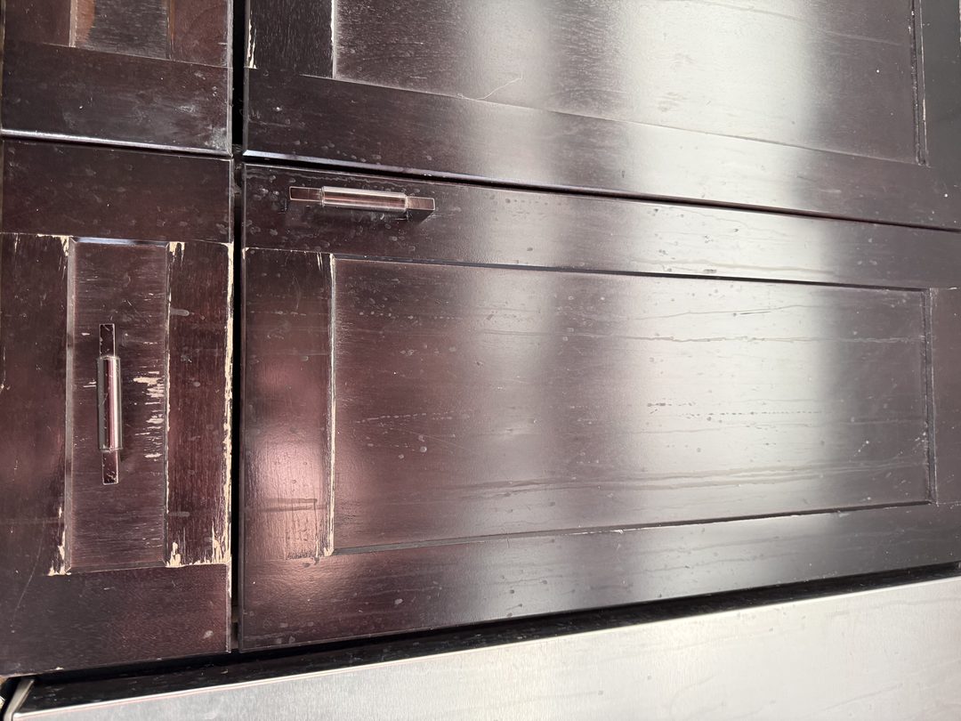 Espresso cabinet finish worn through to bare wood before refinishing in Maple Ridge, Calgary