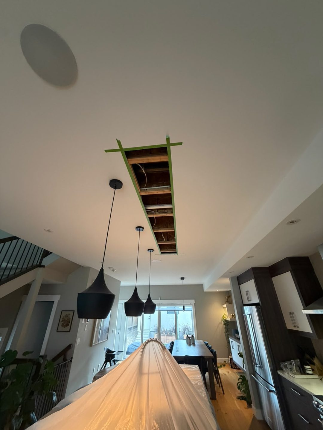 Ceiling cut open to the joists where water-damaged drywall was removed in Mount Pleasant, Calgary