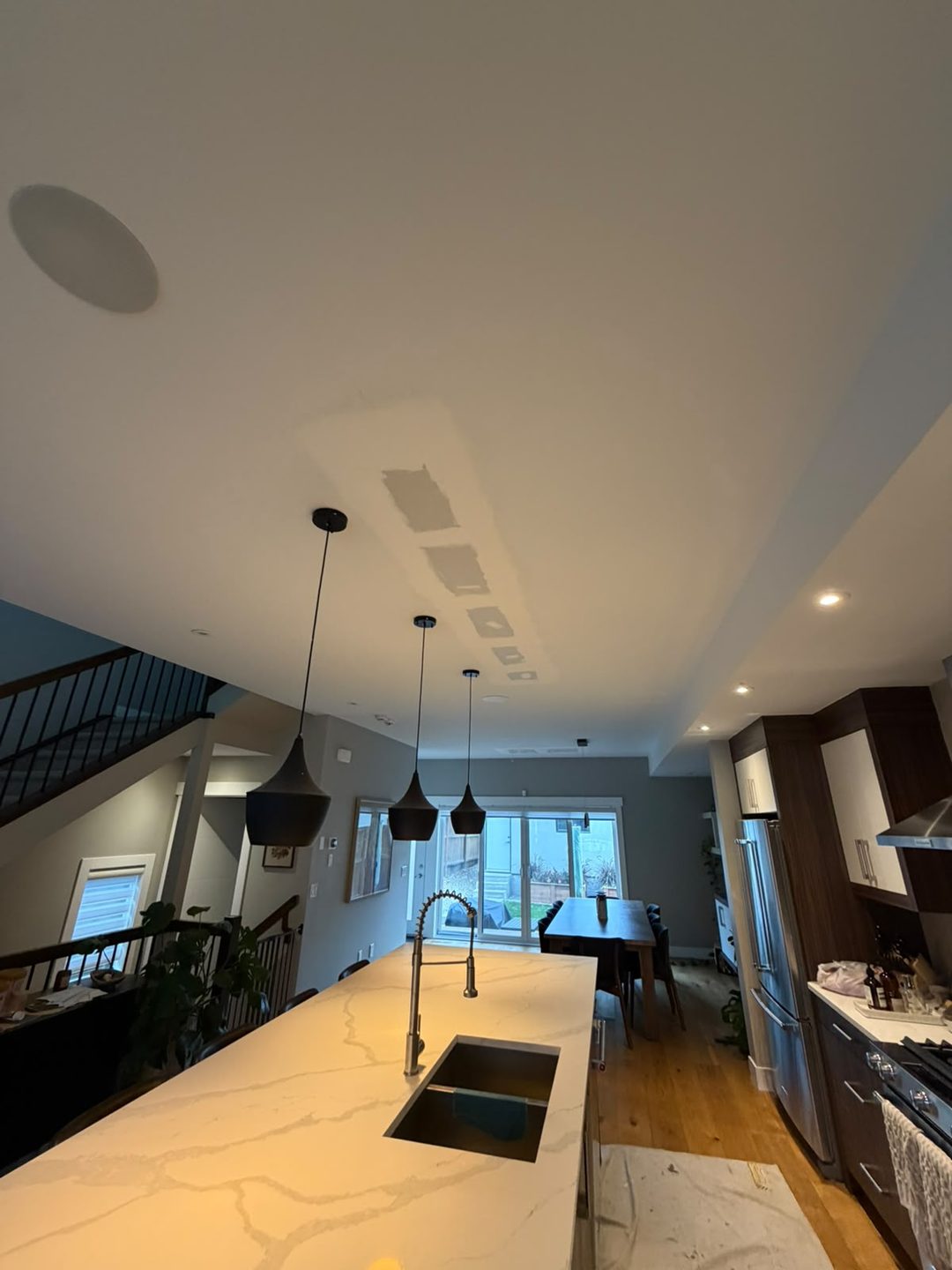Mudded drywall patches drying on a kitchen ceiling in Mount Pleasant, Calgary