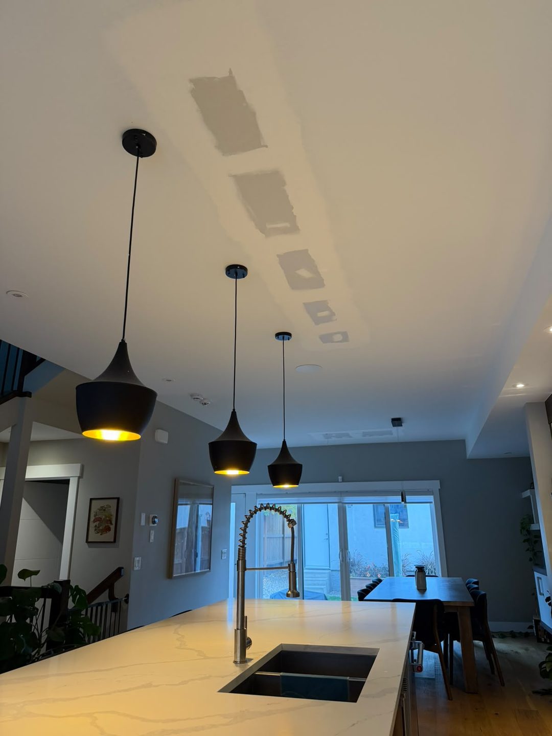 Mudded ceiling patches over a kitchen island in Mount Pleasant, Calgary
