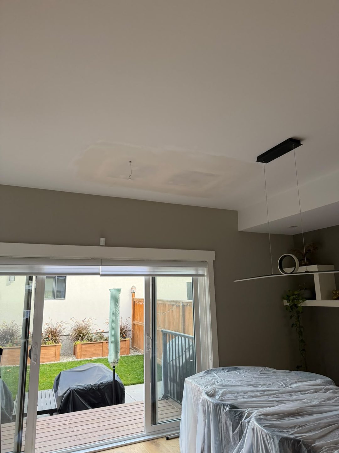 Primed ceiling repair beside patio doors in Mount Pleasant, Calgary
