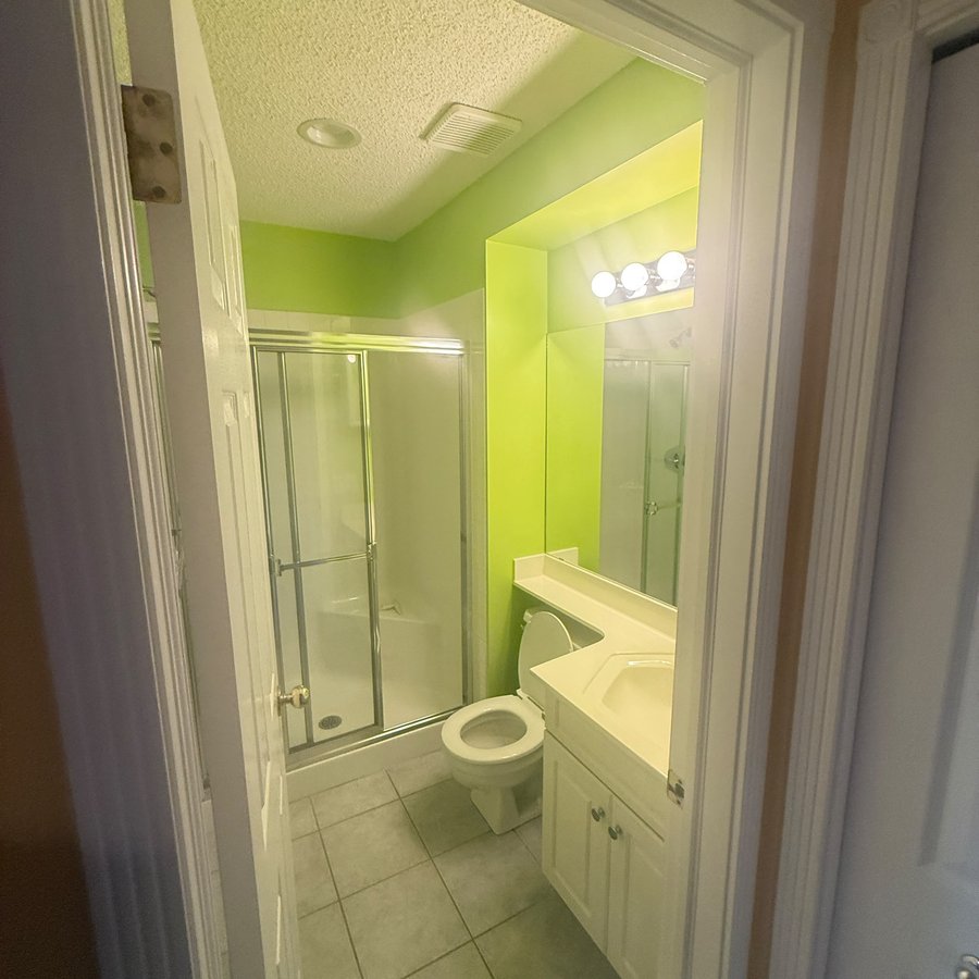 Bathroom with bright lime green walls before repainting in Mount Pleasant, Calgary