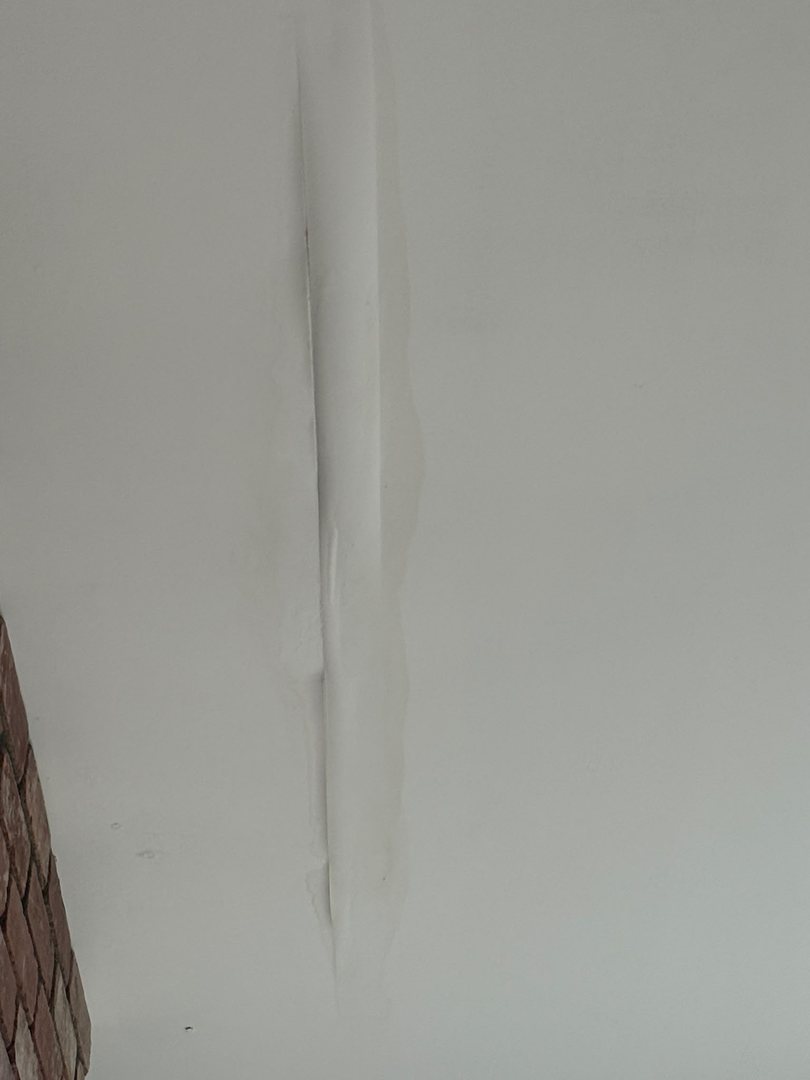 Ceiling drywall tape repair and repaint in Rocky View County, Alberta after water damage: damaged tape removed, new tape applied, seams mudded smooth and the ceiling repainted with colour-matched paint.
