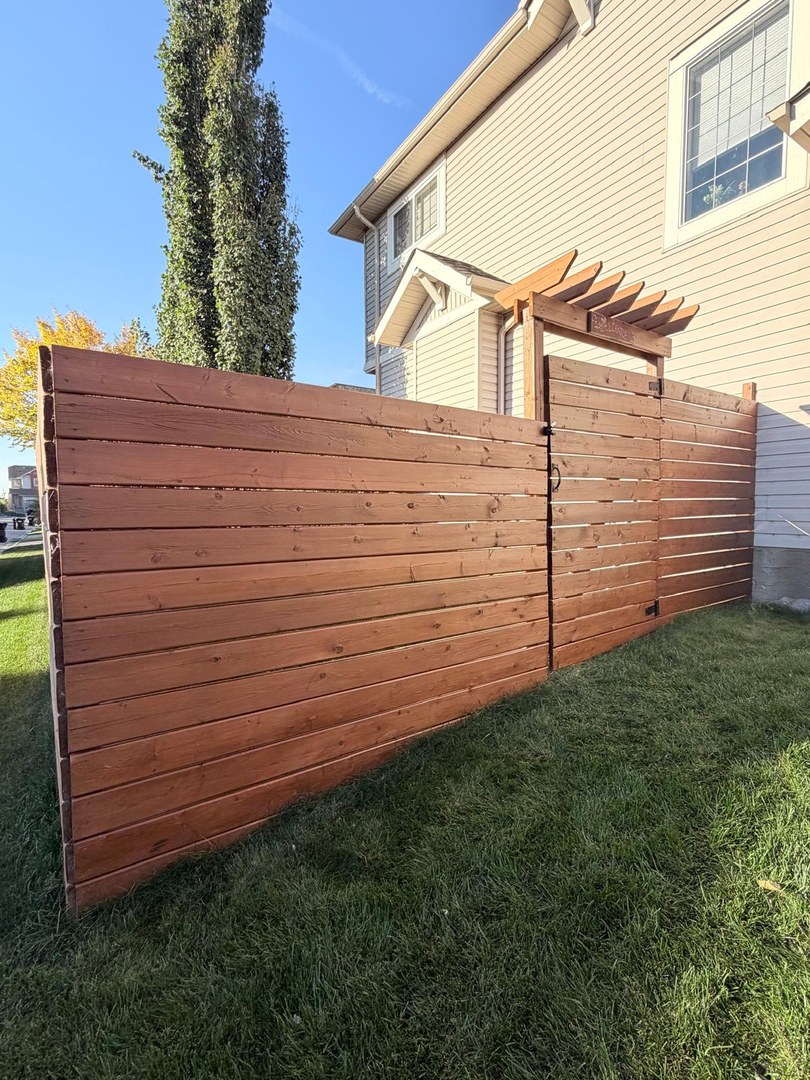 Deck and fence staining in Springbank Hill, Calgary: prep and fresh stain on the deck, fence, gate and pergola for a rich, uniform finish, with a video walkthrough.