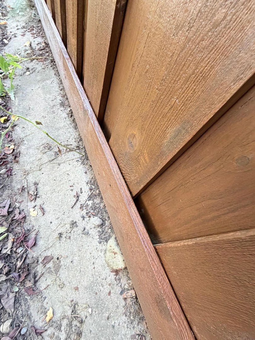 Stained fence base boards detail in Springbank Hill, Calgary