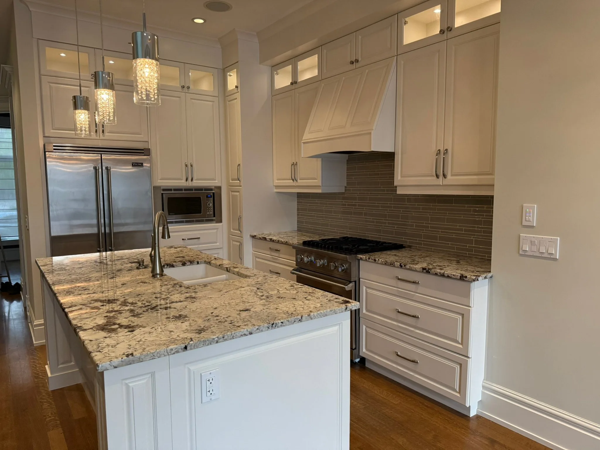Kitchen with refinished white cabinets by MV Painting Inc. in Calgary