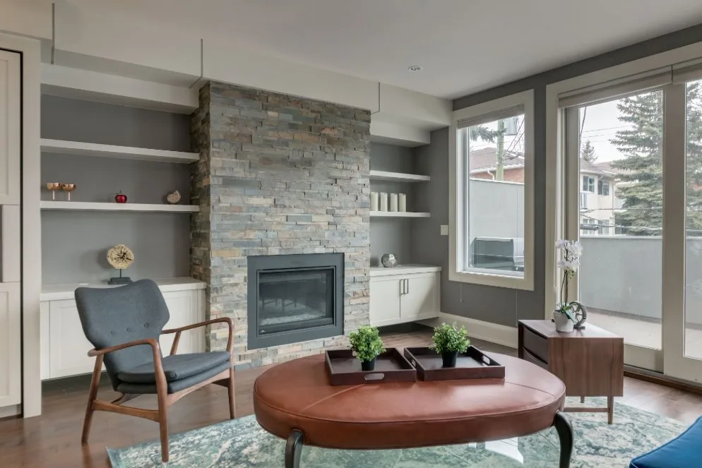 Living room with freshly painted walls and stone fireplace, finished by MV Painting Inc. in Calgary